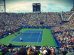 people sitting on bench watching tennis event on field during daytime