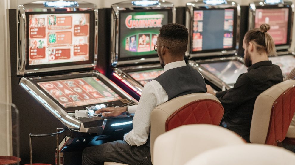 men sitting in front of a slot machine